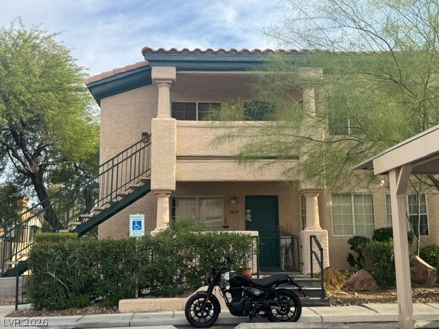 Spanish tile rooflines and classic columns frame the exterior entry of this multi-level residential building.