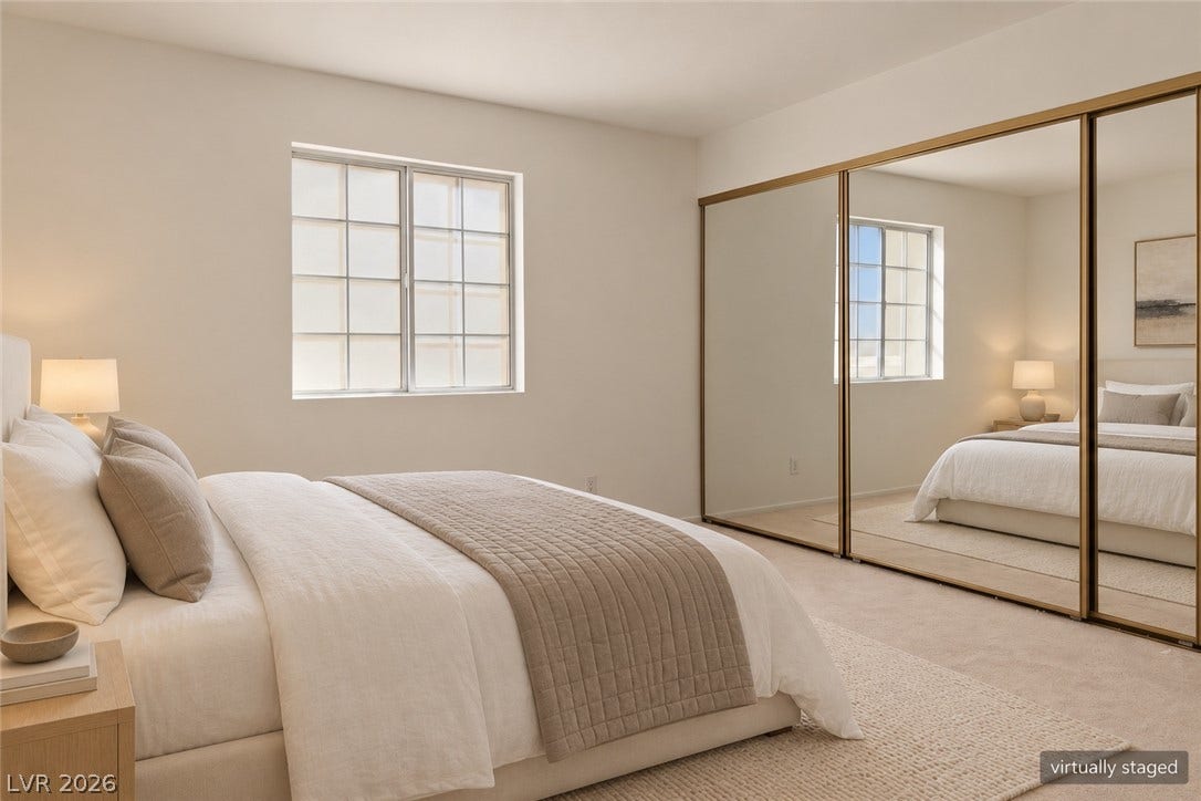 Smooth neutral walls and wall-to-wall carpeting define this comfortable bedroom space.