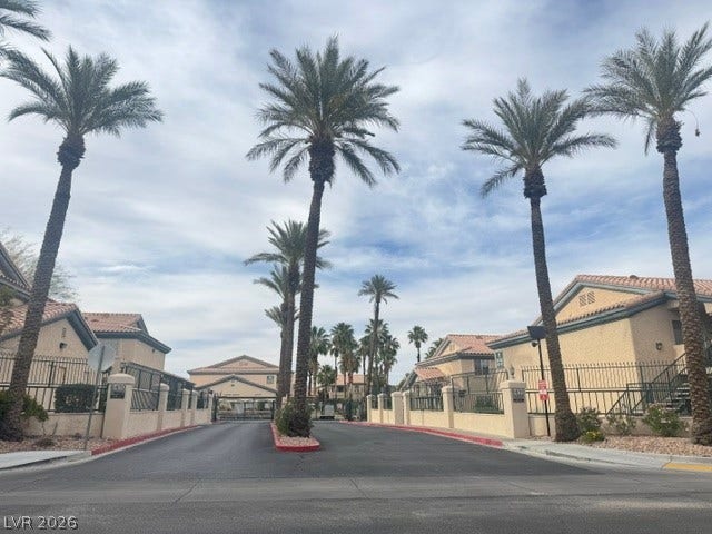 Palm trees frame the gated driveway entry leading into this peaceful residential community.