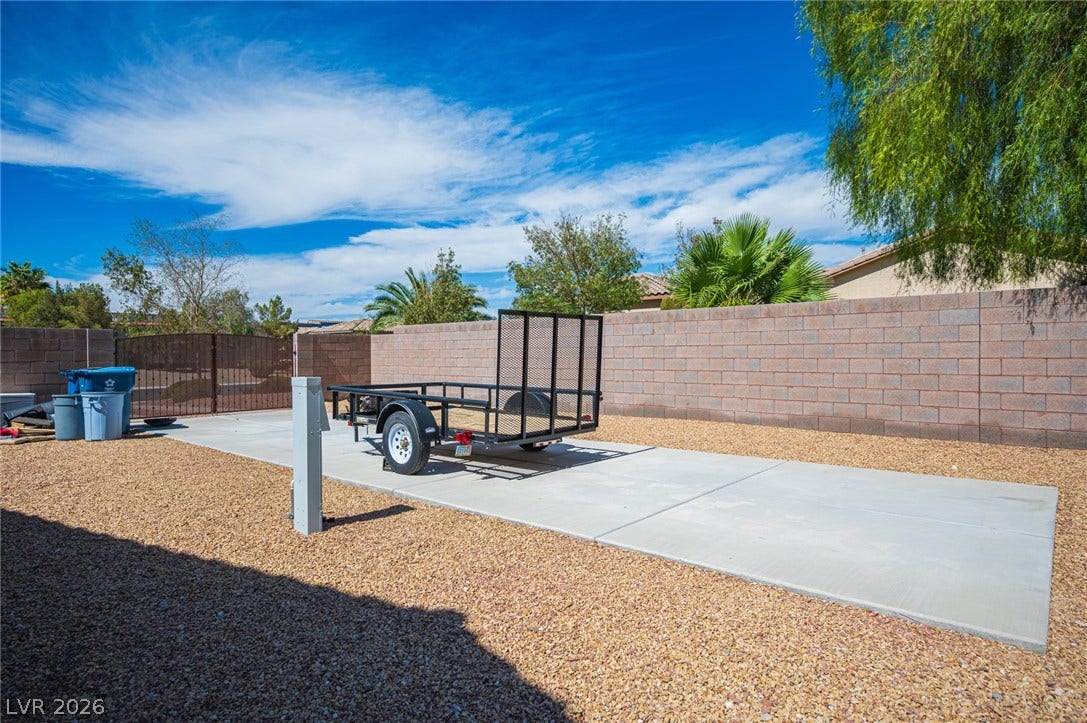 8618 Amber Autumn Street, Las Vegas, NV 89131 Secure block fencing surrounds a spacious paved pad ideal for recreational parking.