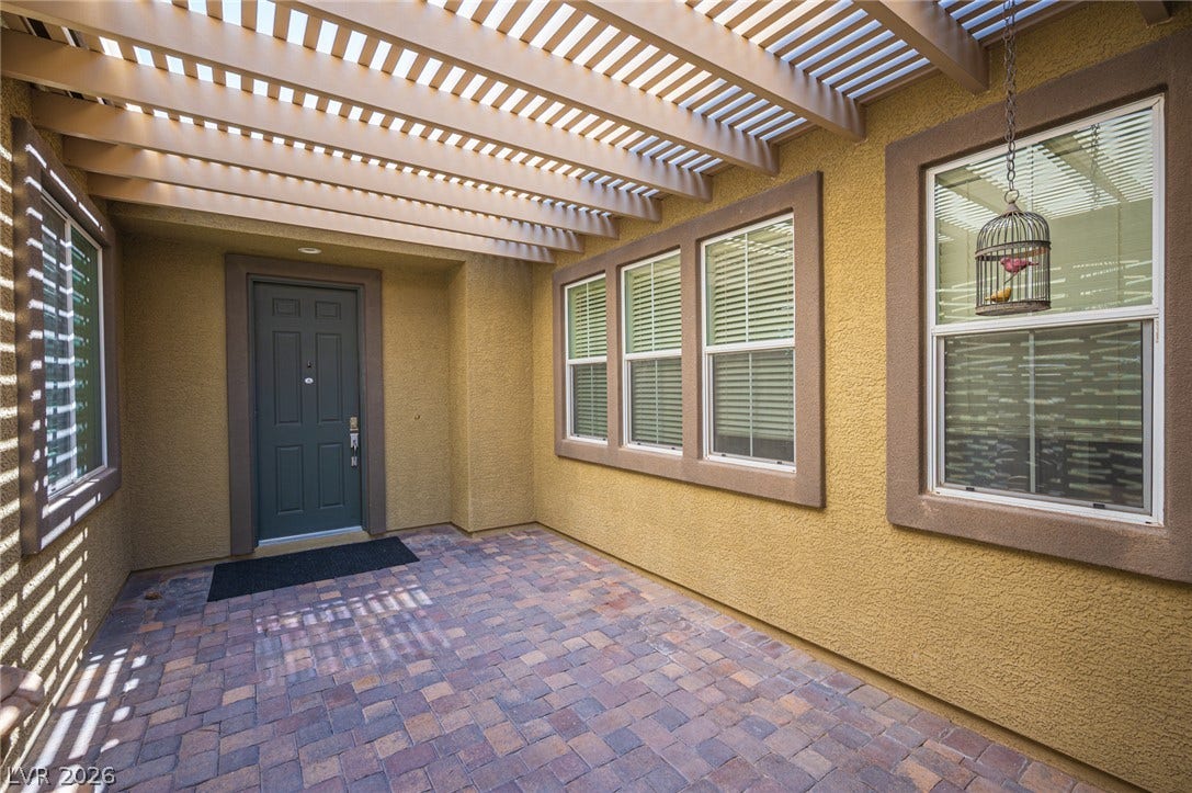 8618 Amber Autumn Street, Las Vegas, NV 89131 A welcoming brick paver entryway rests beneath the shade of a classic wooden pergola.
