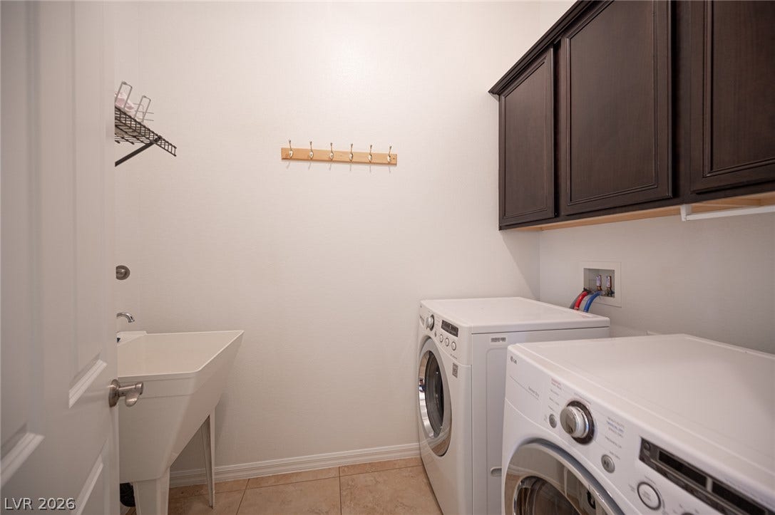 8618 Amber Autumn Street, Las Vegas, NV 89131 Functional laundry room equipped with upper cabinetry, a utility sink, and tile flooring.