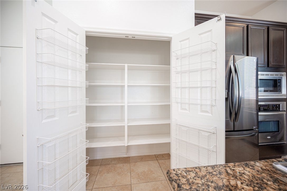 8618 Amber Autumn Street, Las Vegas, NV 89131 A spacious pantry offers abundant built-in shelving adjacent to the kitchen.