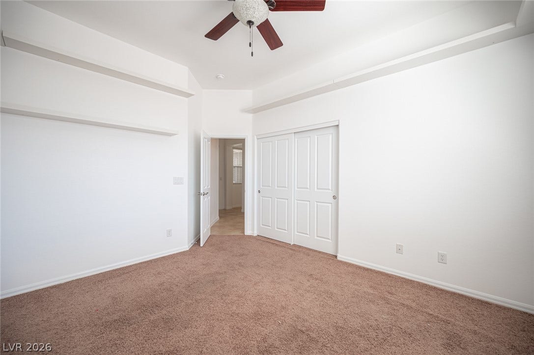 8618 Amber Autumn Street, Las Vegas, NV 89131 A spacious bedroom offers neutral carpeting, clean white walls, and built-in shelving ledges.