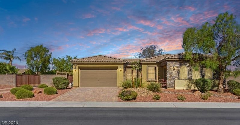 8618 Amber Autumn Street, Las Vegas, NV 89131 Desert landscaping and stone accents frame this single-story home beneath a vibrant sky.