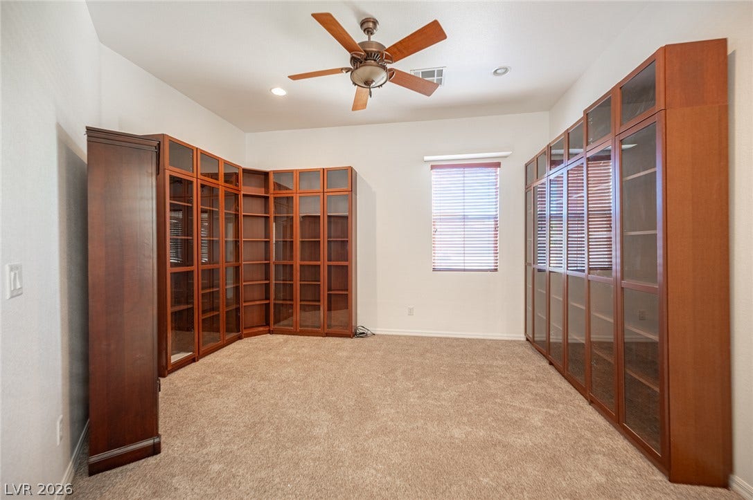 8618 Amber Autumn Street, Las Vegas, NV 89131 Rich wood shelving and plush carpeting define this versatile library or office space.