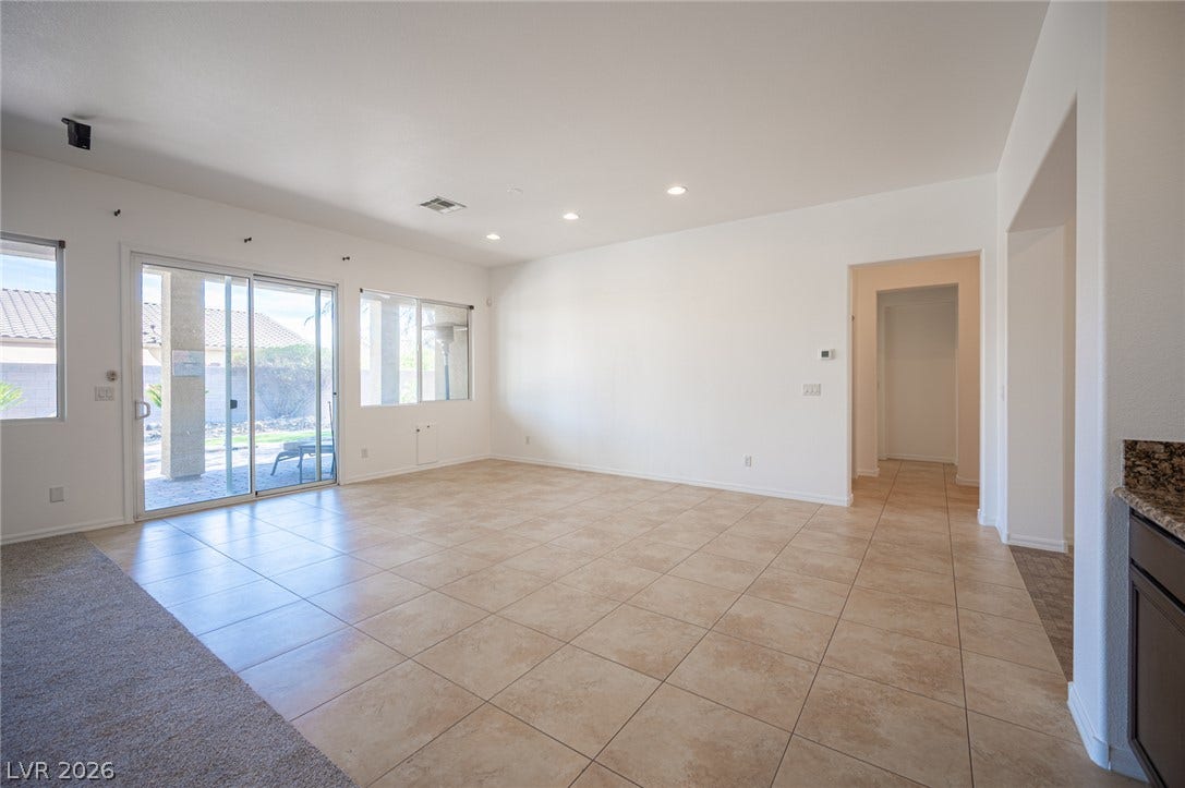8618 Amber Autumn Street, Las Vegas, NV 89131 Tiled flooring and sliding glass doors define this open living area.