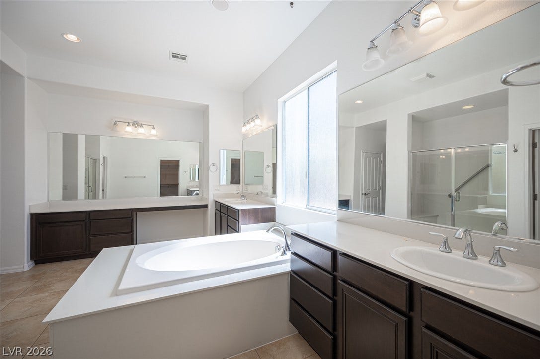 8618 Amber Autumn Street, Las Vegas, NV 89131 A deep soaking tub serves as the centerpiece of this primary bath with dual vanities.