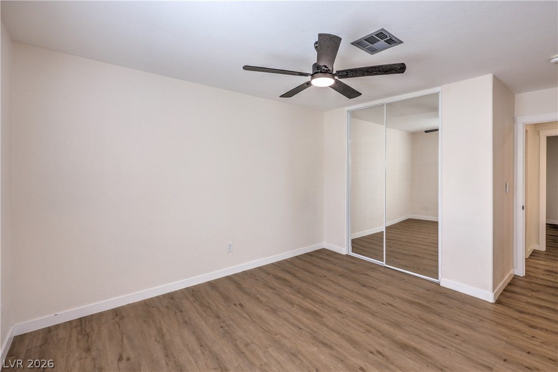 7504 Powder River Court, Las Vegas, NV 89131 Gleaming wood-look floors anchor this versatile room complete with a mirrored sliding closet.
