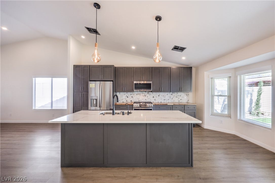 7504 Powder River Court, Las Vegas, NV 89131 A spacious kitchen features a large central island, modern cabinetry, and vaulted ceilings.
