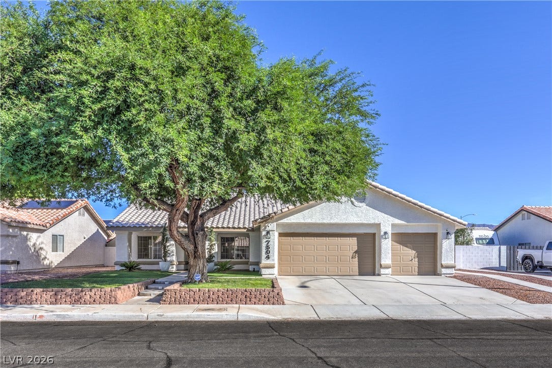 7504 Powder River Court, Las Vegas, NV 89131 An inviting stucco facade is framed by a mature shade tree and a spacious driveway.