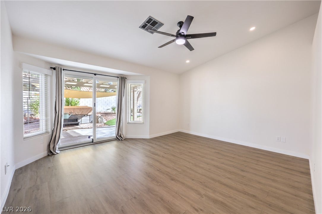 7504 Powder River Court, Las Vegas, NV 89131 Rich wood-inspired floors anchor an airy interior framed by sliding glass doors.