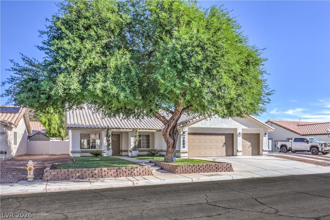 7504 Powder River Court, Las Vegas, NV 89131 A mature shade tree accents the manicured front yard and tile roof of this suburban home.