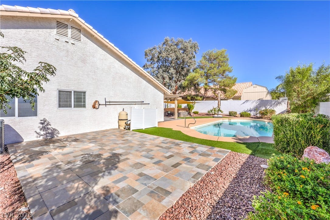 7504 Powder River Court, Las Vegas, NV 89131 Tiled patio spaces and a sparkling swimming pool define this private backyard retreat.