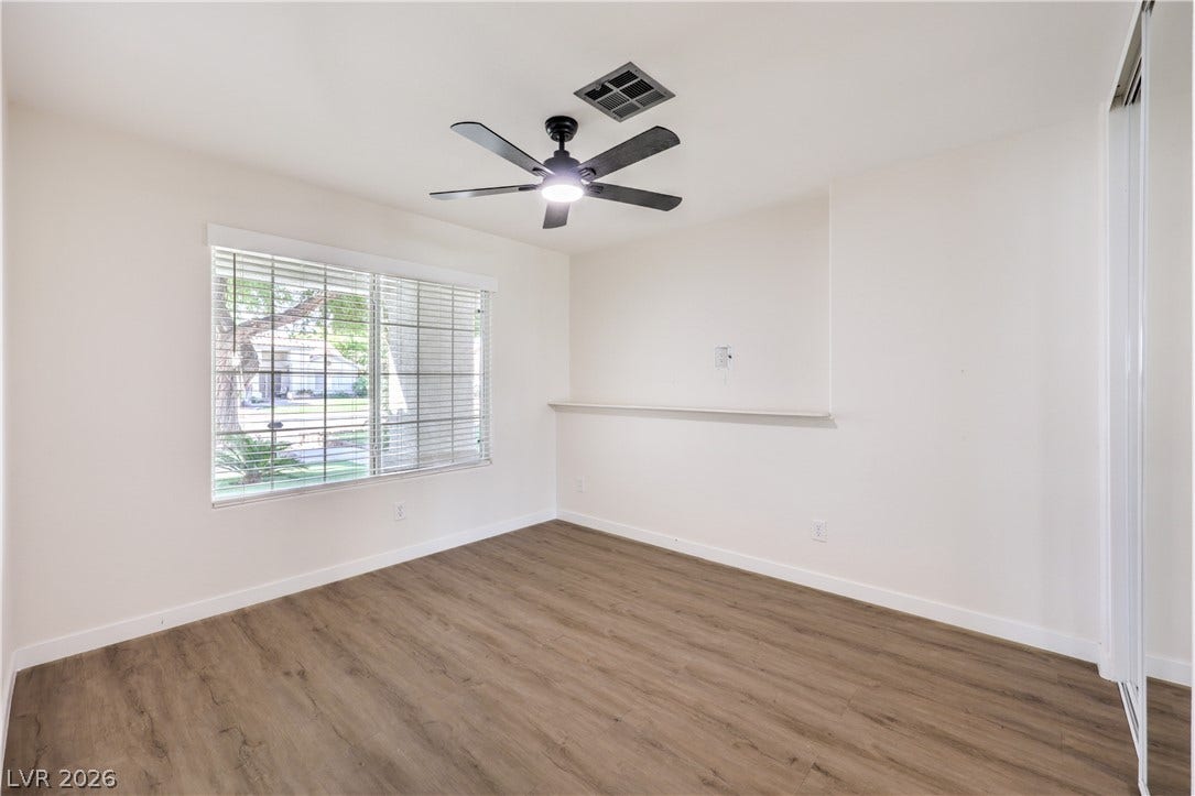 7504 Powder River Court, Las Vegas, NV 89131 Sunlight streams through the large window onto rich wood-look flooring.