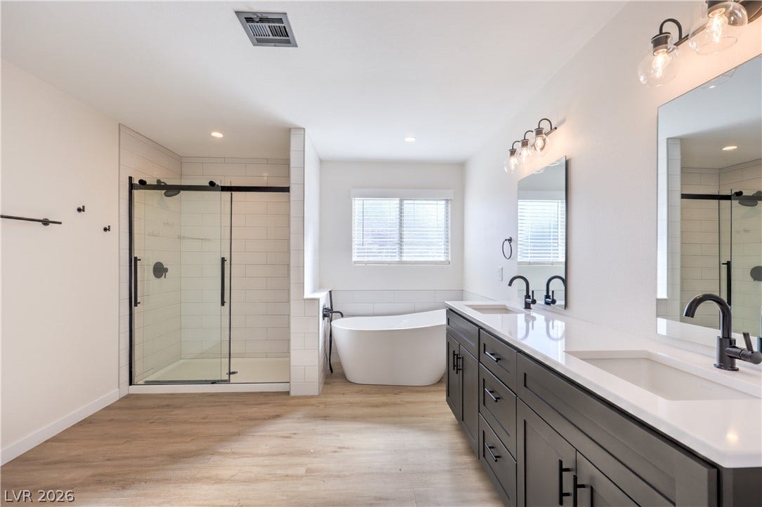 7504 Powder River Court, Las Vegas, NV 89131 A spacious double vanity and a freestanding soaking tub anchor this modern bathroom layout.