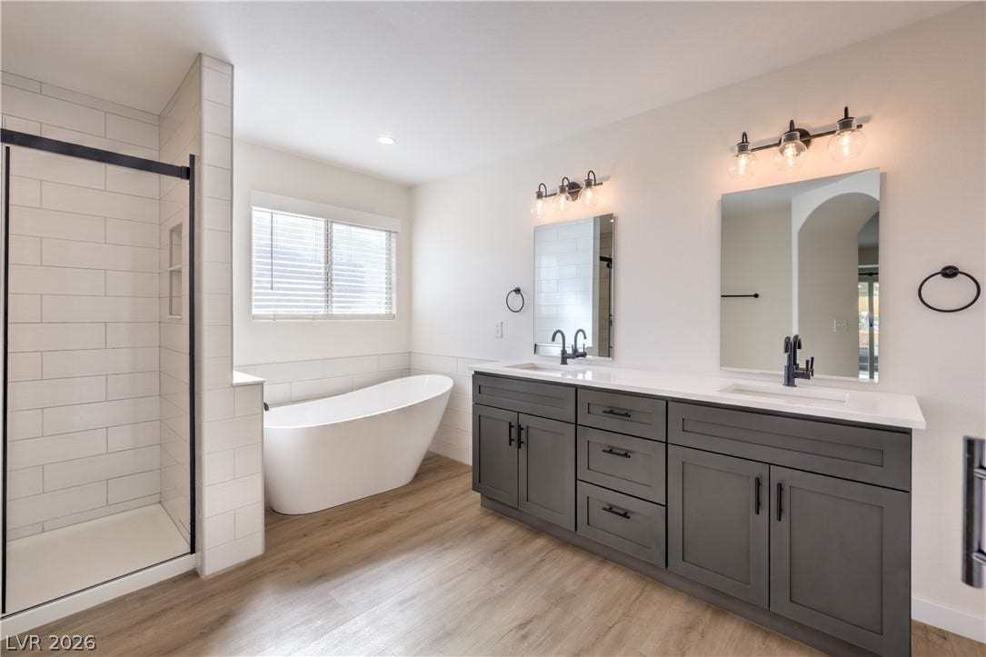 7504 Powder River Court, Las Vegas, NV 89131 A spacious double vanity and a freestanding soaking tub anchor this modern primary bathroom.