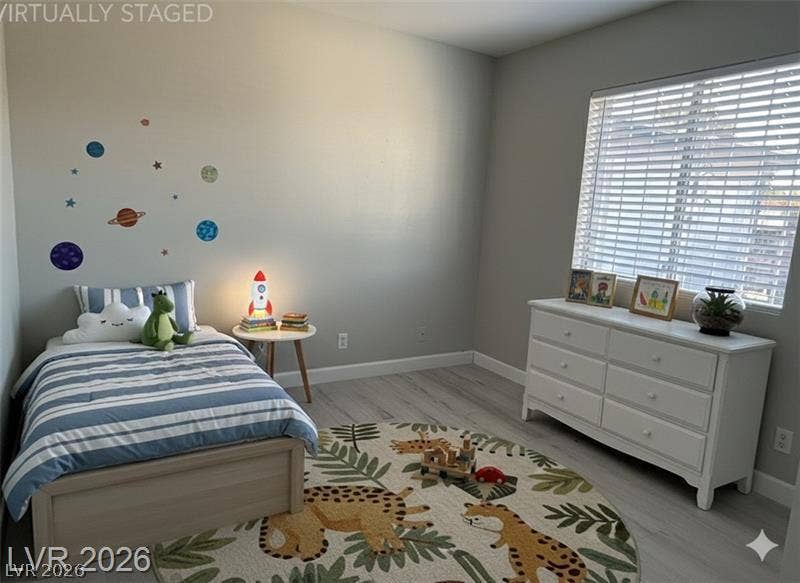 6489 Bugbee Avenue, Las Vegas, NV 89103 A sunny bedroom reveals wide-plank wood flooring and a large window facing the front yard.