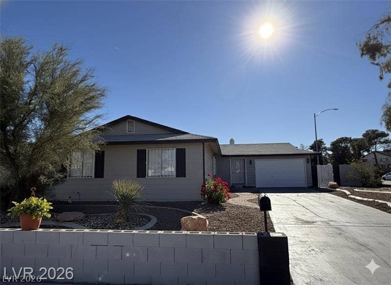 6489 Bugbee Avenue, Las Vegas, NV 89103 Desert landscaping and a paved driveway lead to this single-story home with an attached garage.