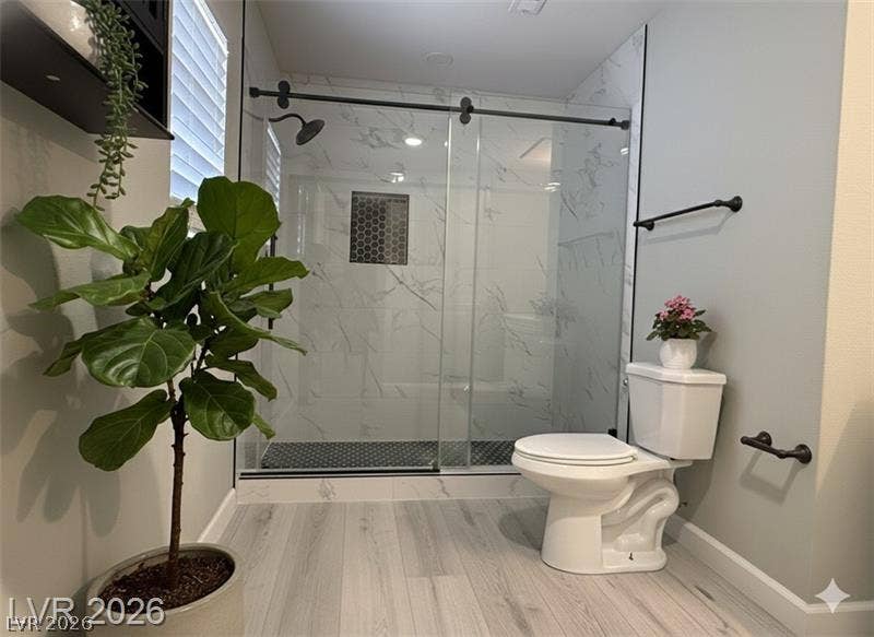 6489 Bugbee Avenue, Las Vegas, NV 89103 Modern finishes define this washroom complete with a glass-enclosed walk-in shower and tile surrounds.