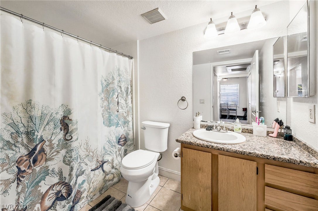 5055 W Hacienda Avenue, #1136, Las Vegas, NV 89118 A well-appointed bathroom includes a granite-topped vanity and classic tile flooring.