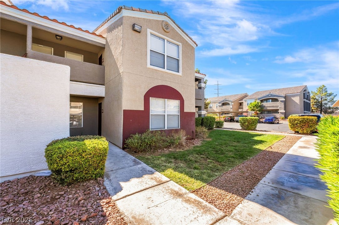 5055 W Hacienda Avenue, #1136, Las Vegas, NV 89118 Concrete walkways trace through manicured green lawns alongside the classic stucco exterior.