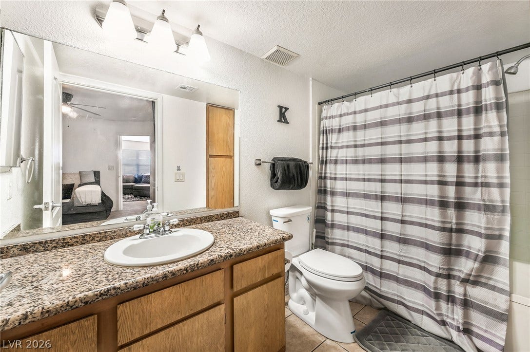 5055 W Hacienda Avenue, #1136, Las Vegas, NV 89118 Polished granite countertops complement the warm wood vanity in this well-appointed bathroom.