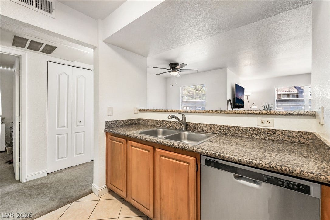 5055 W Hacienda Avenue, #1136, Las Vegas, NV 89118 Polished granite countertops and classic wooden cabinetry elevate this functional kitchen space.