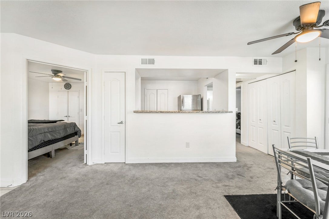 5055 W Hacienda Avenue, #1136, Las Vegas, NV 89118 An open layout connects the carpeted living space to a practical kitchen pass-through.