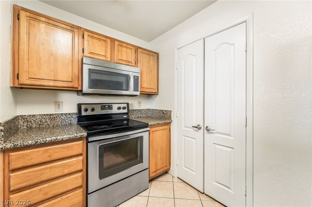 5055 W Hacienda Avenue, #1136, Las Vegas, NV 89118 Warm wood cabinetry and granite countertops frame the stainless steel appliances in this functional kitchen.