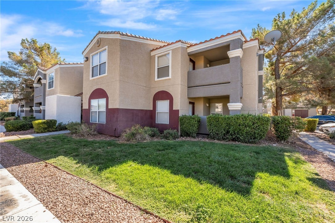 5055 W Hacienda Avenue, #1136, Las Vegas, NV 89118 Multi-level stucco exterior showcases classic architectural lines framed by established green lawns.
