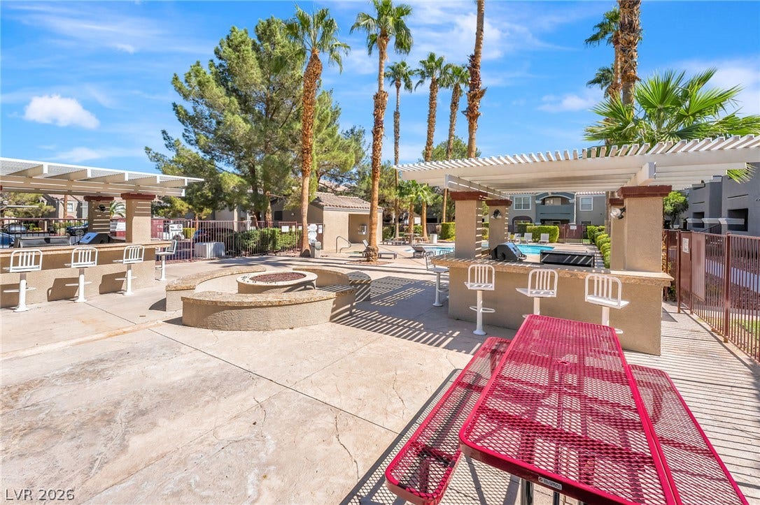 5055 W Hacienda Avenue, #1136, Las Vegas, NV 89118 Lush palm trees surround this community patio area with outdoor grilling stations and a fire pit.