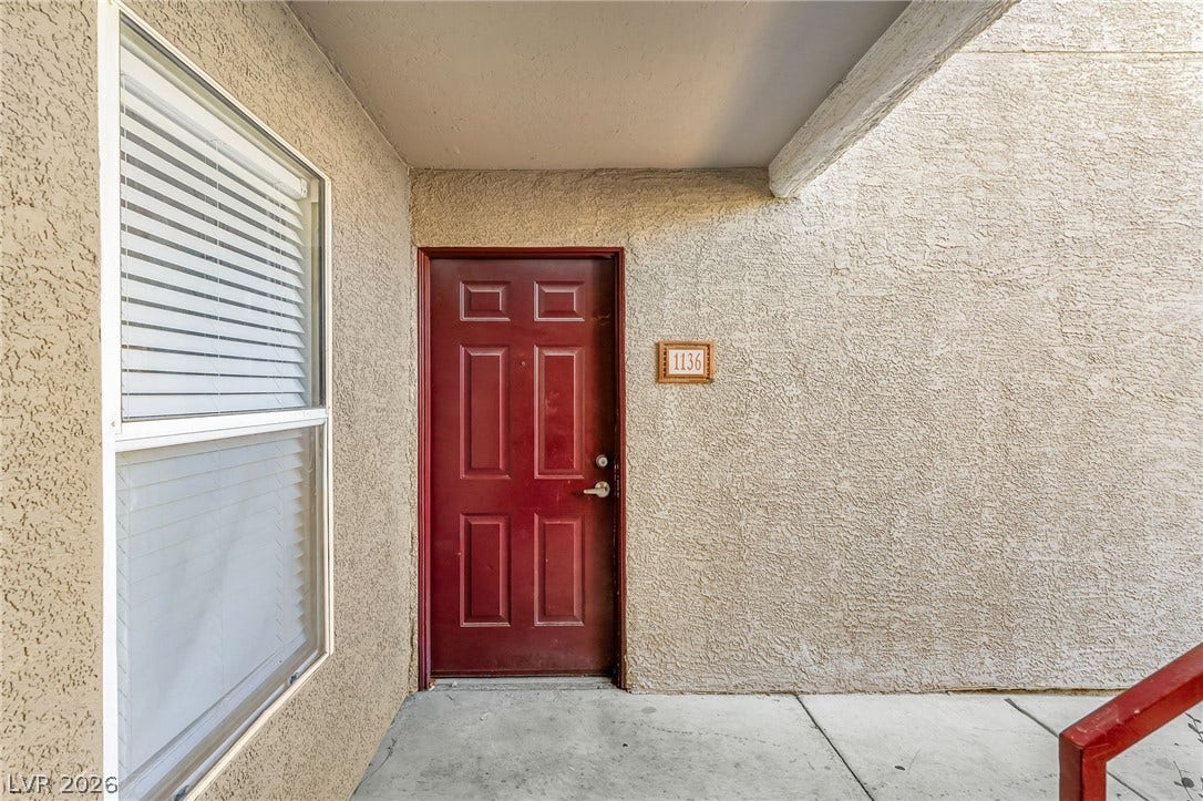 5055 W Hacienda Avenue, #1136, Las Vegas, NV 89118 A covered concrete entryway features durable stucco walls and a classic paneled entry door.