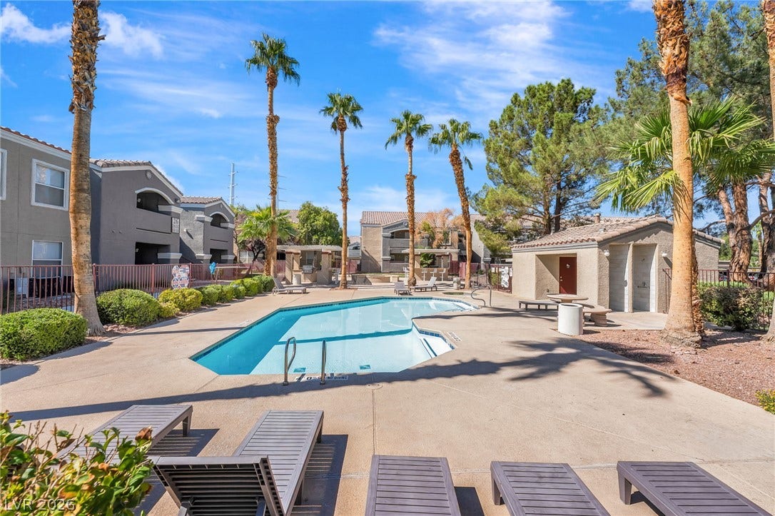 5055 W Hacienda Avenue, #1136, Las Vegas, NV 89118 Manicured palm trees frame a sparkling community swimming pool under clear blue skies.