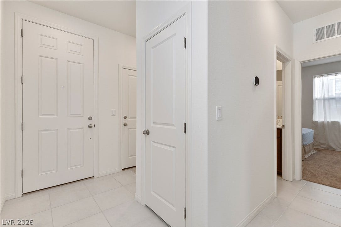 10034 Sir Atlas Court, Las Vegas, NV 89148 A welcoming entryway transitions seamlessly into neutral tiled hallways leading to adjacent living spaces.