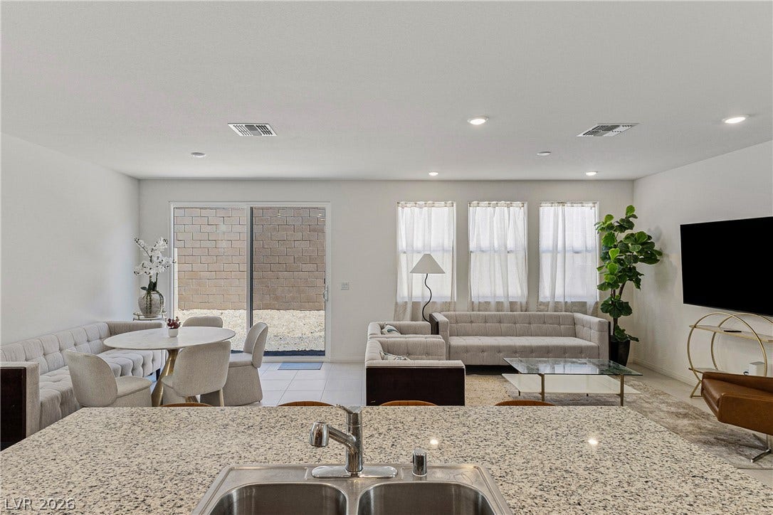 10034 Sir Atlas Court, Las Vegas, NV 89148 Granite counters overlook a fluid living and dining layout with sliding doors.
