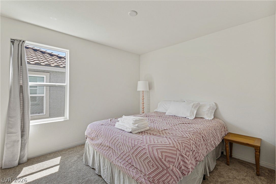 10034 Sir Atlas Court, Las Vegas, NV 89148 Plentiful natural light streams across plush carpeting in this serene bedroom space.