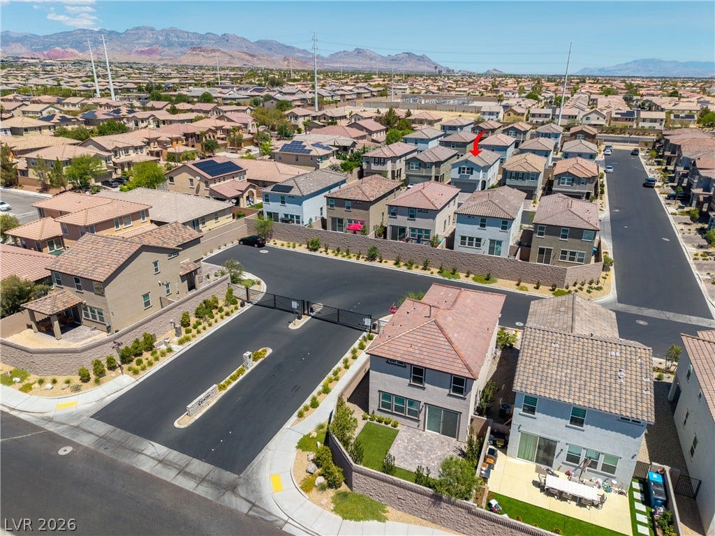 10034 Sir Atlas Court, Las Vegas, NV 89148 An aerial perspective showcases a neat residential cul-de-sac set against distant mountain peaks.