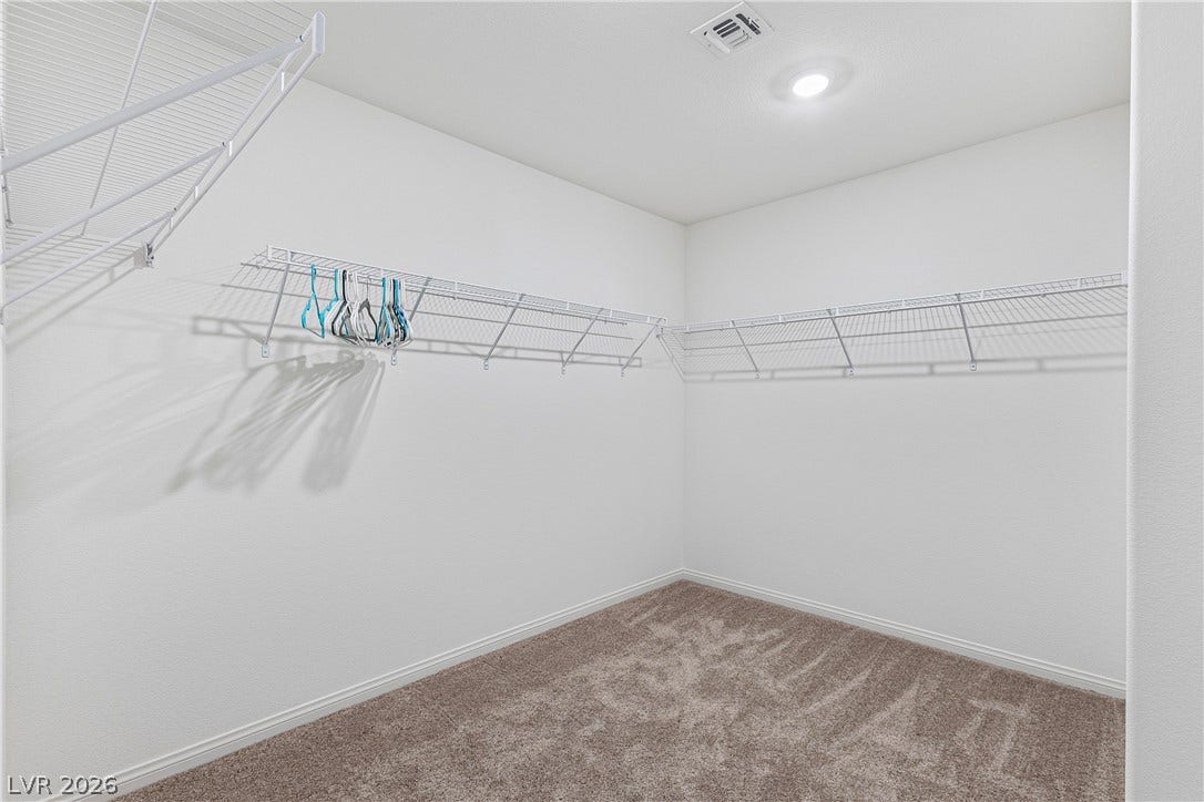 10034 Sir Atlas Court, Las Vegas, NV 89148 An organized walk-in closet boasts soft carpeting and abundant wire shelving under recessed lighting.