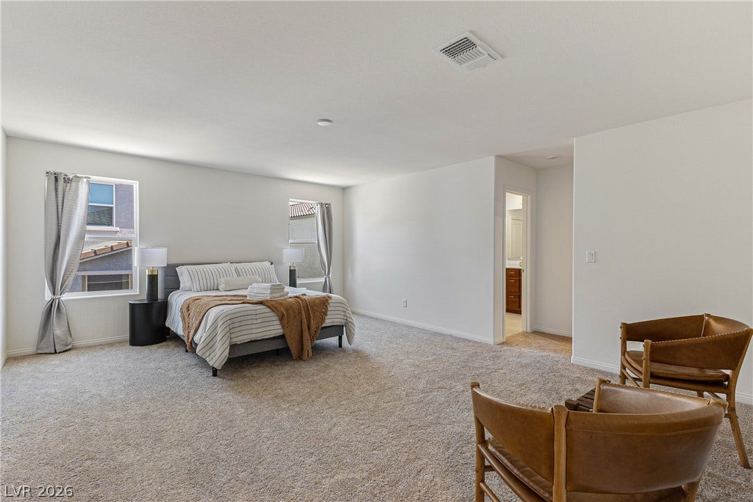 10034 Sir Atlas Court, Las Vegas, NV 89148 A spacious bedroom layout features soft wall-to-wall carpeting and an adjoining private bathroom entry.
