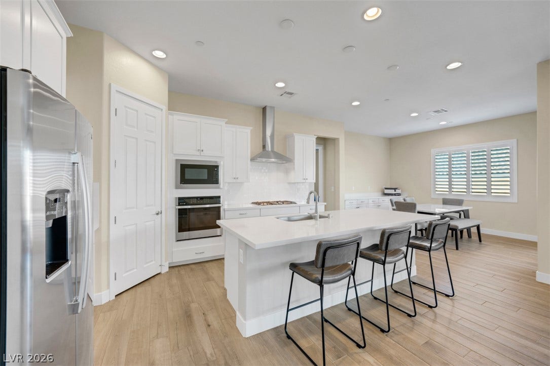 Gleaming wood-look floors complement modern cabinetry and an expansive central island.