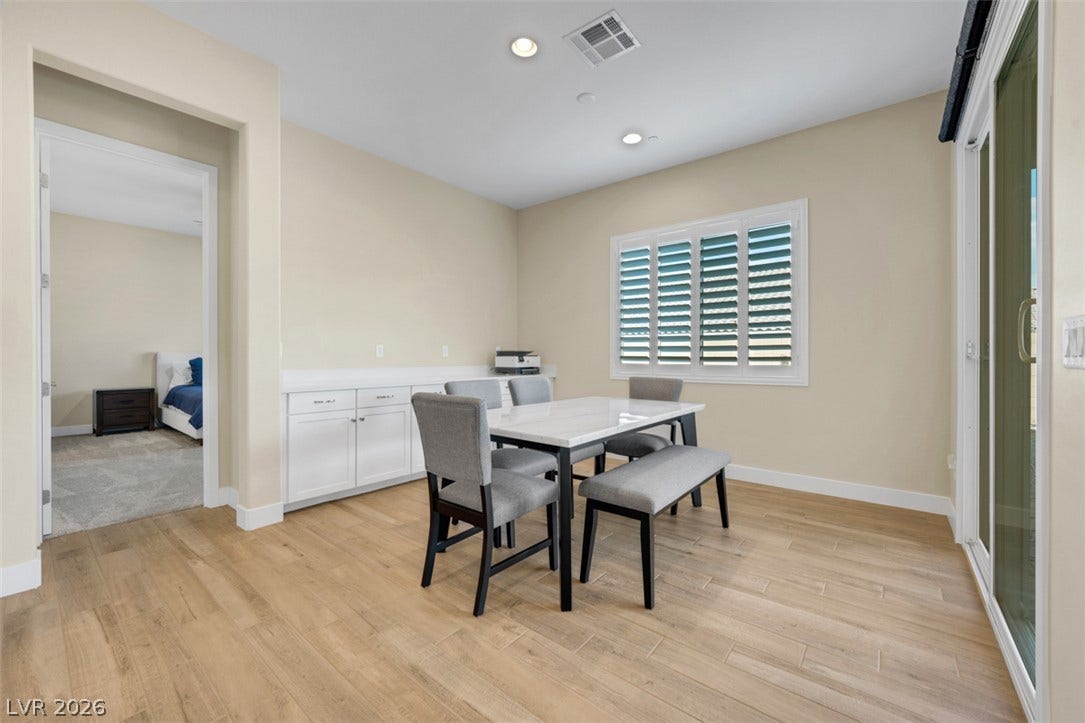 A spacious dining area with wood-look flooring connects directly to the backyard sliding doors.