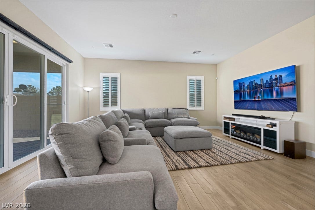 Gleaming wood-look floors and glass sliding doors enhance this airy modern living space.