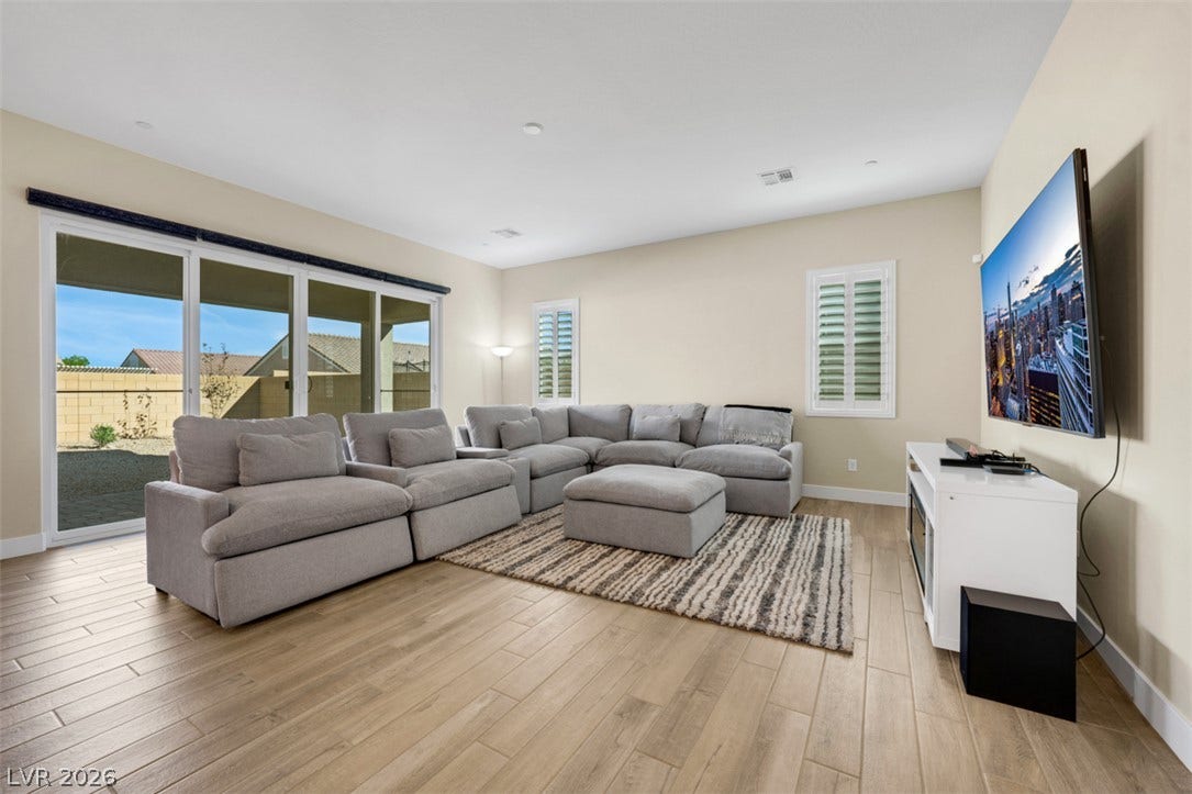 Gleaming wood-look tile floors and sliding glass doors define this open living space.