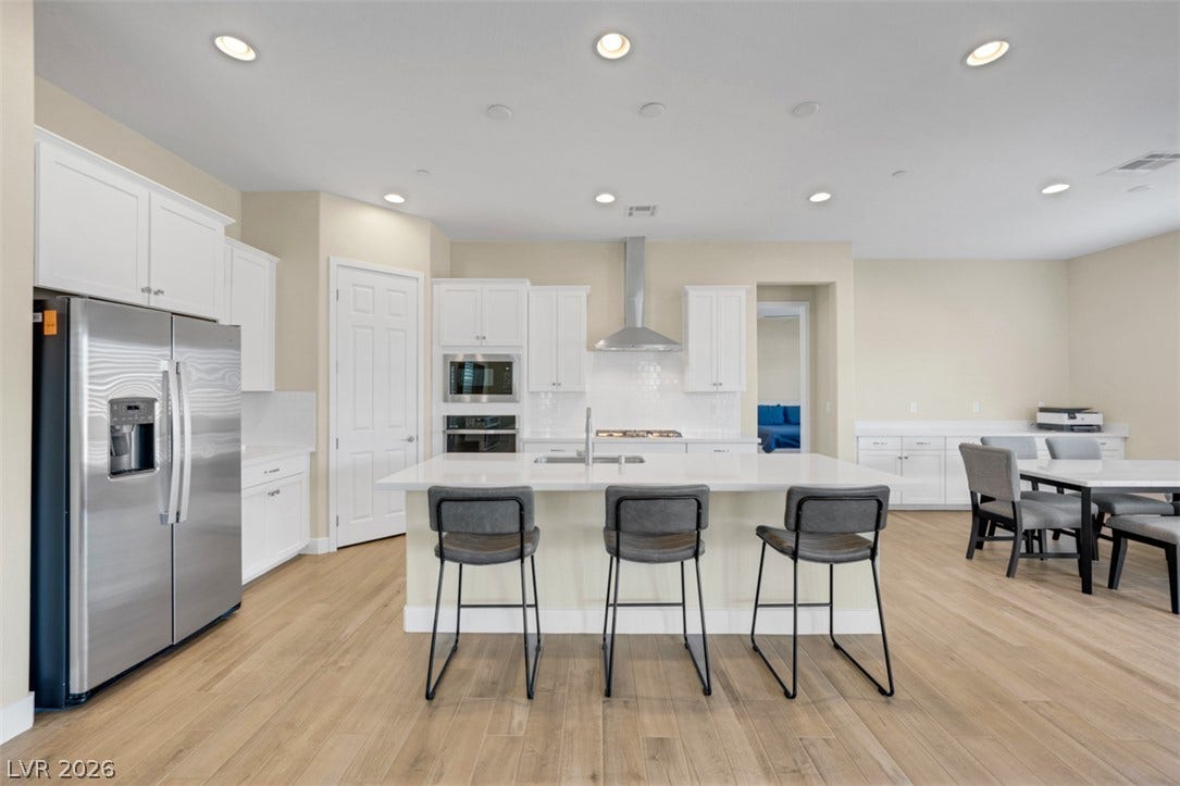 Recessed lighting illuminates this modern kitchen with stone countertops and a spacious central island.