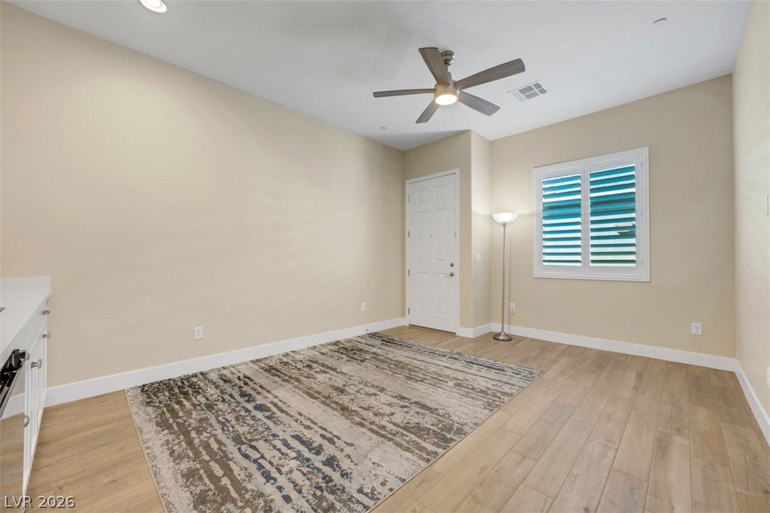 Warm wood-look flooring and plantation shutters bring timeless character to this versatile living space.