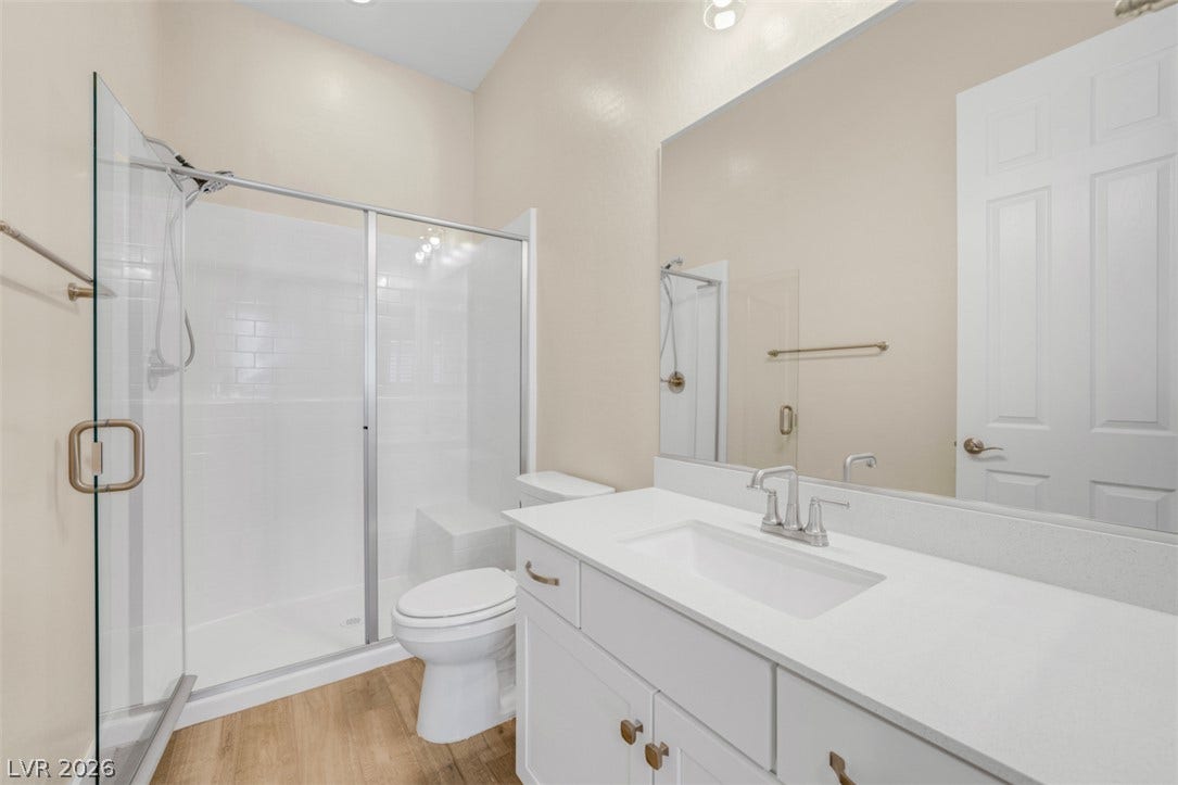 High ceilings and a glass-enclosed shower highlight this modern vanity space.