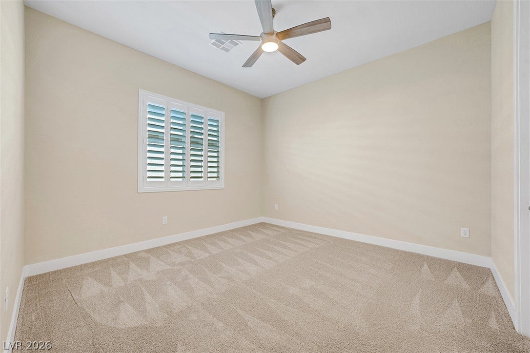 Plush carpeting and plantation shutters highlight this versatile secondary bedroom space.