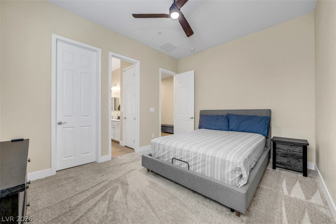 A comfortable bedroom features soft carpeting and convenient access to an en-suite bathroom.