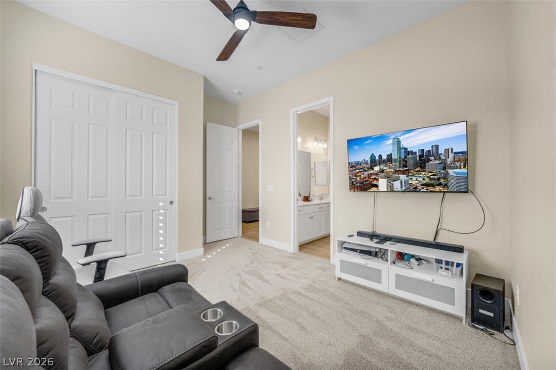 Soft carpeting pairs with high ceilings in this versatile secondary bedroom space.